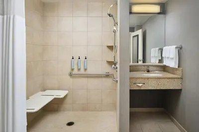 a bathroom with a sink and a toilet and a mirror at Courtyard by Marriott Akron Stow in Stow