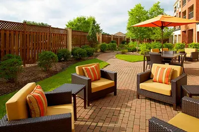 a patio with chairs and tables and an umbrella at Courtyard by Marriott Akron Stow in Stow