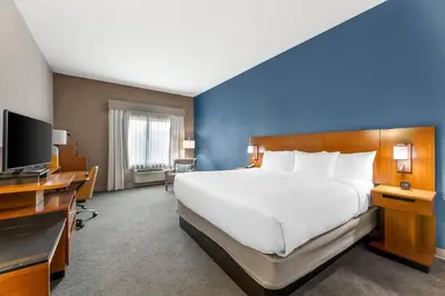a hotel room with a large bed and a television at Comfort Inn & Suites Akron South in Akron