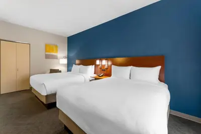 a hotel room with two beds and a blue wall at Comfort Inn & Suites Akron South in Akron