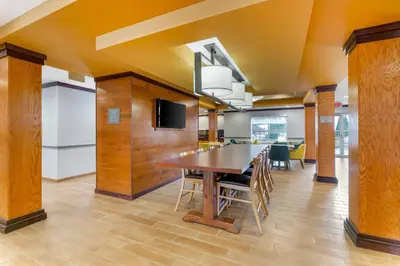 a dining room with a wooden table and chairs at Comfort Inn & Suites Akron South in Akron
