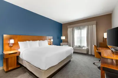 a hotel room with a large bed and a desk at Comfort Inn & Suites Akron South in Akron