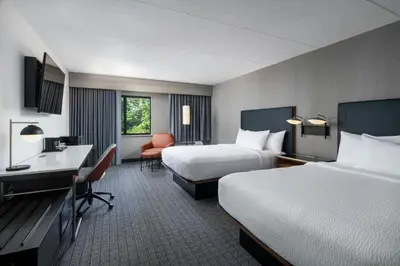 a hotel room with two beds and a desk at Courtyard Cleveland Beachwood in Beachwood