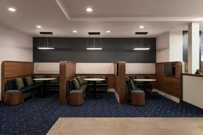 a dining room with tables and chairs and lights at Courtyard Cleveland Beachwood in Beachwood
