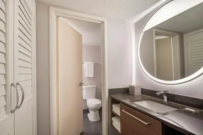 a bathroom with a toilet and a sink and a mirror at Courtyard Cleveland Beachwood in Beachwood
