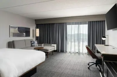 a hotel room with a bed and a couch and a desk at Courtyard Cleveland Beachwood in Beachwood