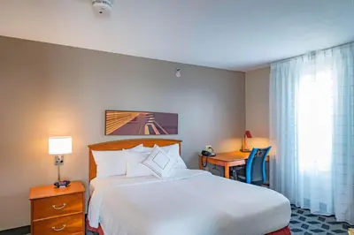 a hotel room with a bed and a desk with a chair at TownePlace Suites Cleveland Streetsboro in Streetsboro