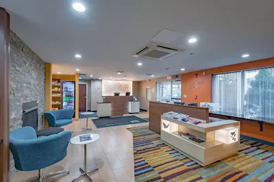 an office with a lobby with blue chairs and a fireplace at Fairfield Inn & Suites by Marriott Cleveland Streetsboro in Streetsboro