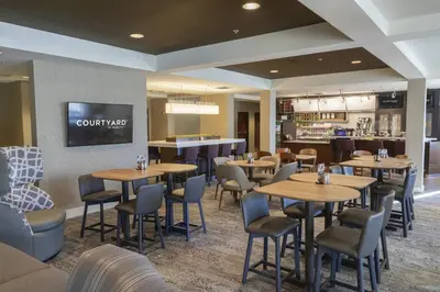 a restaurant with tables and chairs and a bar at Courtyard by Marriott Cleveland Willoughby in Willoughby