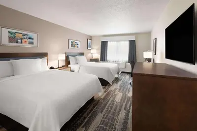 a hotel room with two beds and a flat screen tv at Wingate by Wyndham Marion in Marion