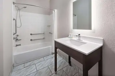 a white bathroom with a sink and a bath tub at Wingate by Wyndham Marion in Marion