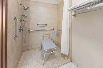 a shower with a stool in a bathroom at Wingate by Wyndham Marion in Marion