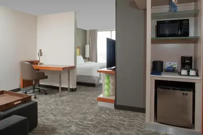 a hotel room with a room with a bed and a desk at SpringHill Suites Cincinnati North Forest Park in Springdale