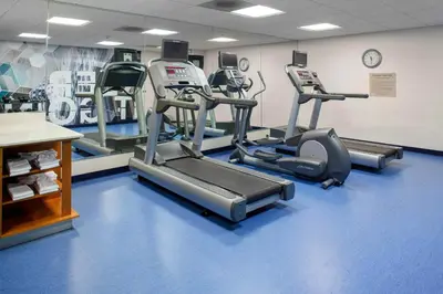 a gym with several tread machines on a blue floor at SpringHill Suites Cincinnati North Forest Park in Springdale