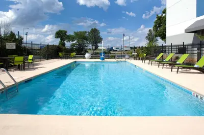 a large swimming pool with chairs and a table at SpringHill Suites Cincinnati North Forest Park in Springdale