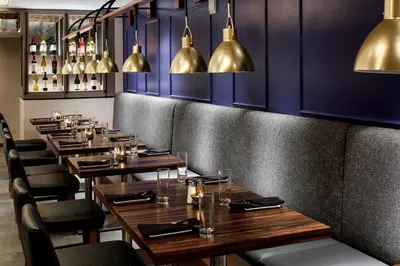a row of tables in a restaurant with gold pendants at Marriott Cincinnati North in West Chester