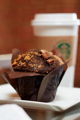 a chocolate muffin on a plate next to a cup of coffee at Marriott Cincinnati North in West Chester