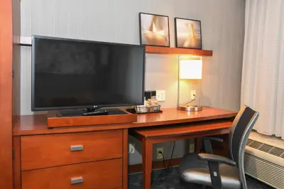 a hotel room with a desk with a television on it at Courtyard Cincinnati North at Union Centre in West Chester