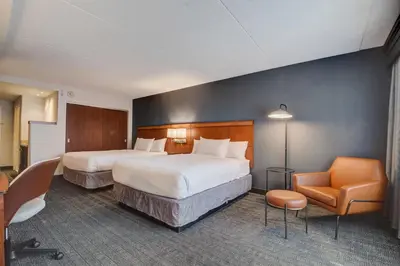 a hotel room with two beds and a chair at Courtyard Cincinnati North at Union Centre in West Chester