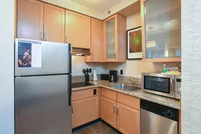 a kitchen with wooden cabinets and a stainless steel refrigerator at Residence Inn Cincinnati North West Chester in West Chester