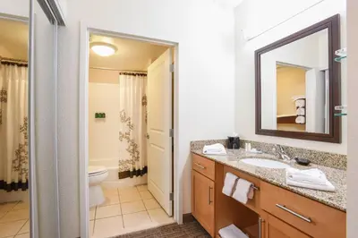 a bathroom with a sink and a toilet and a mirror at Residence Inn Cincinnati North West Chester in West Chester