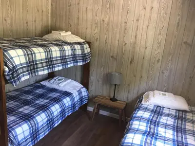 a room with two beds and a table with a lamp at Little Ted's Cottages in Marblehead