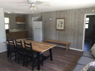 a kitchen and dining room with a wooden table and chairs at Little Ted's Cottages in Marblehead