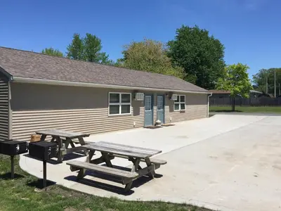 a building with two picnic tables in front of it at Little Ted's Cottages in Marblehead