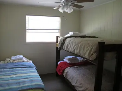 a bedroom with two bunk beds and a ceiling fan at Little Ted's Cottages in Marblehead