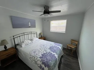 a bedroom with a bed and a ceiling fan at Little Ted's Cottages in Marblehead