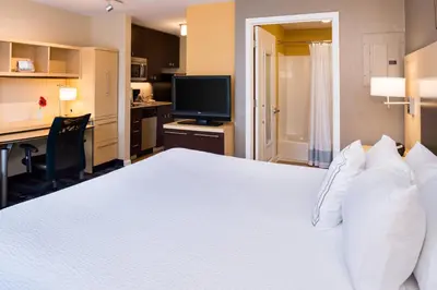 a bedroom with a large white bed and a desk at TownePlace Suites Huntington in Huntington