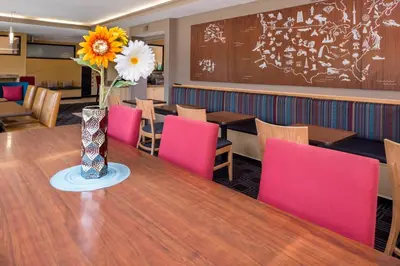 a dining room with a table and pink chairs at TownePlace Suites Huntington in Huntington