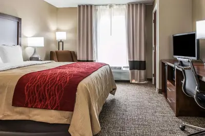 a hotel room with a bed and a flat screen tv at Comfort Inn & Suites Mount Sterling in Mount Sterling