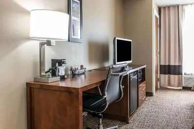 a hotel room with a desk with a television and a chair at Comfort Inn & Suites Mount Sterling in Mount Sterling