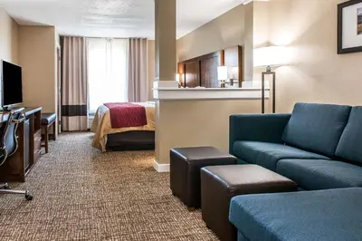 a hotel room with a couch and a bed at Comfort Inn & Suites Mount Sterling in Mount Sterling