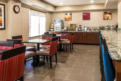 a restaurant with tables and chairs and a counter at Comfort Inn & Suites Mount Sterling in Mount Sterling