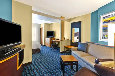 a hotel room with a couch and a television at Fairfield Inn & Suites by Marriott Lexington North in Lexington