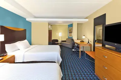a hotel room with two beds and a flat screen tv at Fairfield Inn & Suites by Marriott Lexington North in Lexington