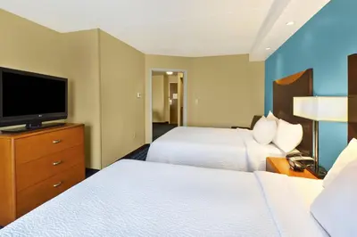 a hotel room with two beds and a flat screen tv at Fairfield Inn & Suites by Marriott Lexington North in Lexington