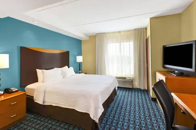 a hotel room with a bed and a flat screen tv at Fairfield Inn & Suites by Marriott Lexington North in Lexington