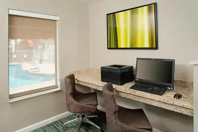 a desk with a computer on it with two chairs at Residence Inn by Marriott Lexington North in Lexington