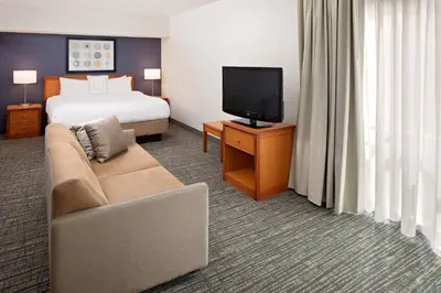 a hotel room with a bed and a couch and a television at Residence Inn by Marriott Lexington North in Lexington