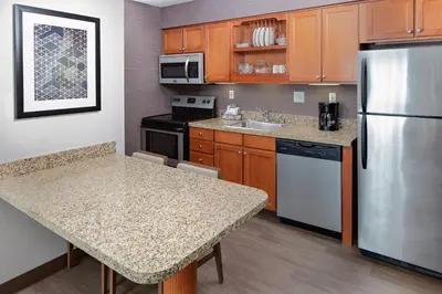 a kitchen with wooden cabinets and a stainless steel refrigerator at Residence Inn by Marriott Lexington North in Lexington