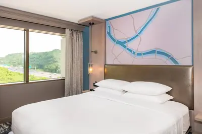 a bed in a hotel room with a mural on the wall at Pittsburgh Airport Marriott in Robinson Township