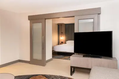 a living room with a tv and a bedroom at Pittsburgh Airport Marriott in Robinson Township