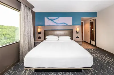 a large bed in a room with a large window at Pittsburgh Airport Marriott in Robinson Township