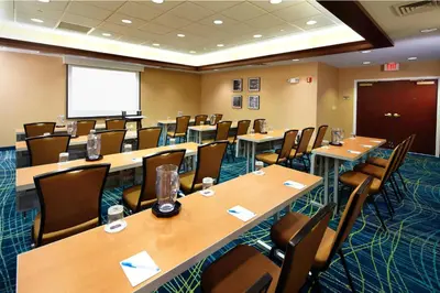 a conference room with tables and chairs and a screen at SpringHill Suites by Marriott Pittsburgh Washington in Washington