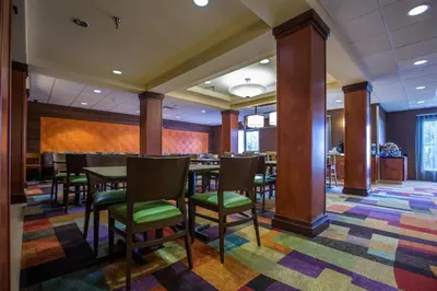 a restaurant with tables and chairs on a colorful rug at Fairfield Inn & Suites Toledo North in Toledo
