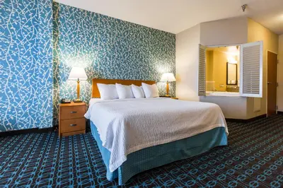 a hotel room with a large bed and a mirror at Fairfield Inn & Suites Toledo North in Toledo
