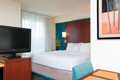 a hotel room with a bed and a flat screen tv at Residence Inn Toledo Maumee in Maumee